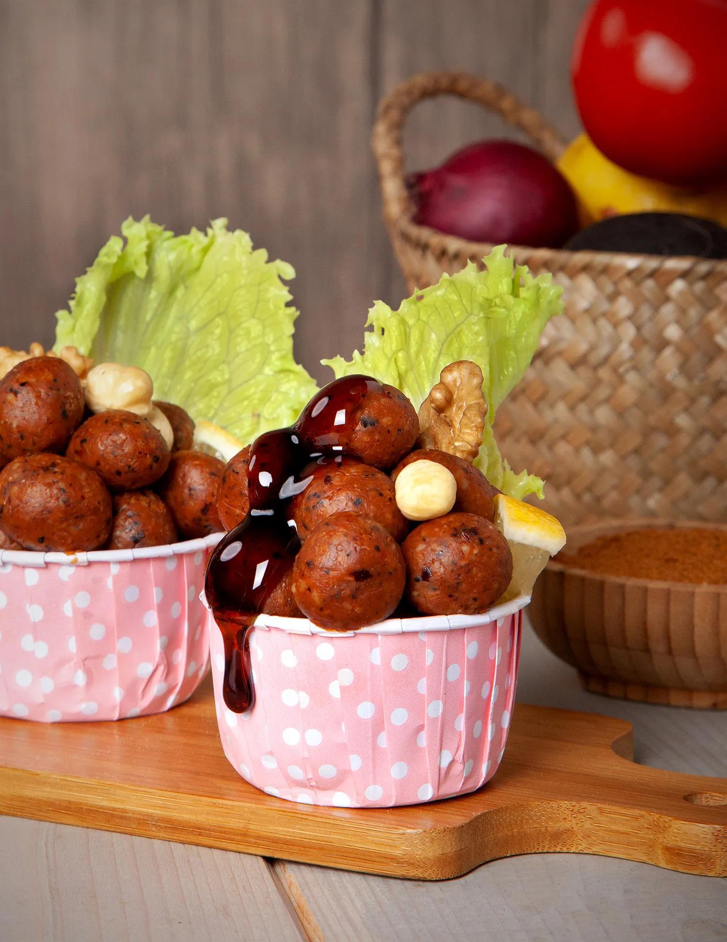 Proje: Ziyafet Çiğköfte Pembe puantiyeli karton kaselerde minik çiğ köfte topları, üzerine nar ekşisi dökülmüş.